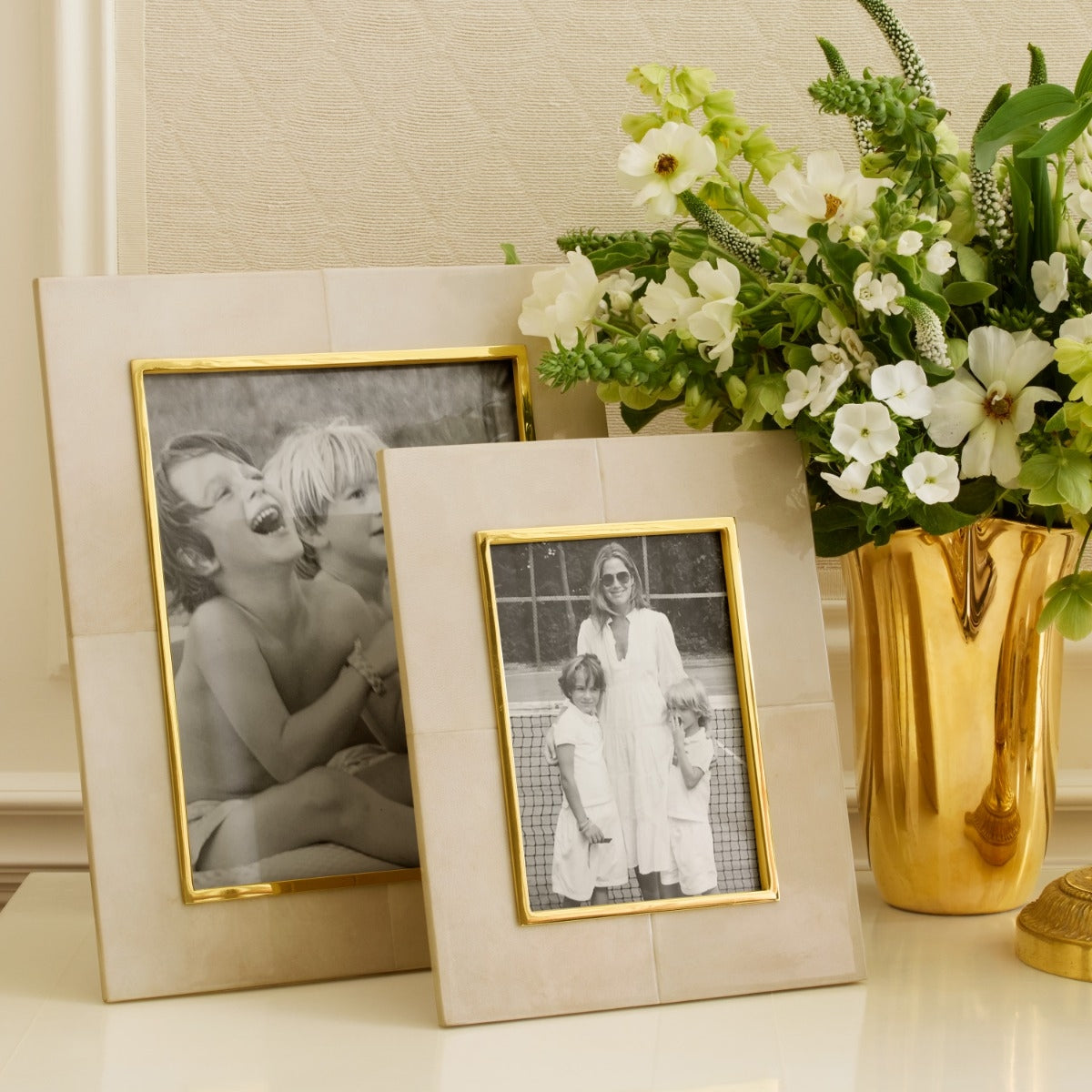 Beige photo frame with gold border on a white background