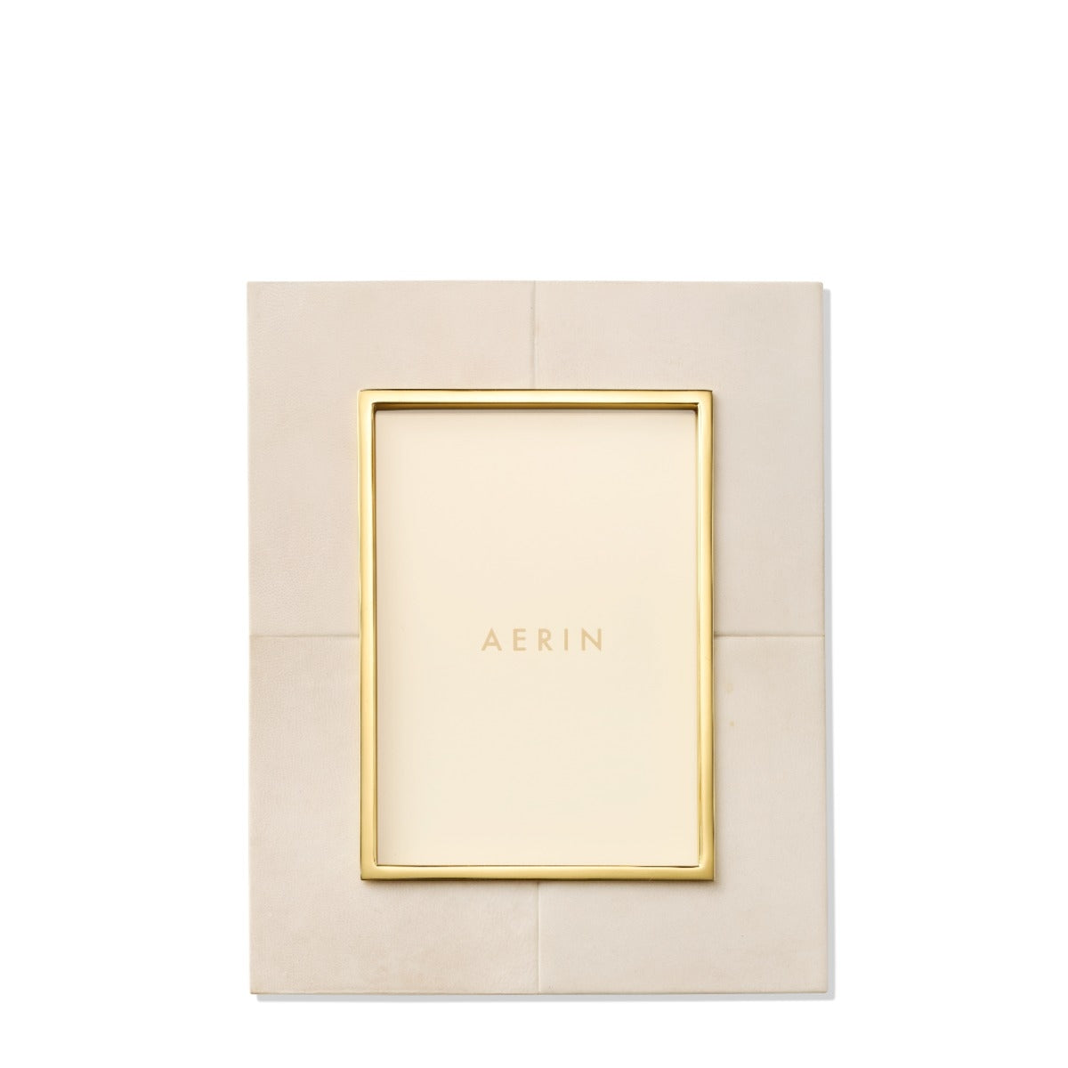 Gold picture frame on a beige textured background with 'AERIN' branding.