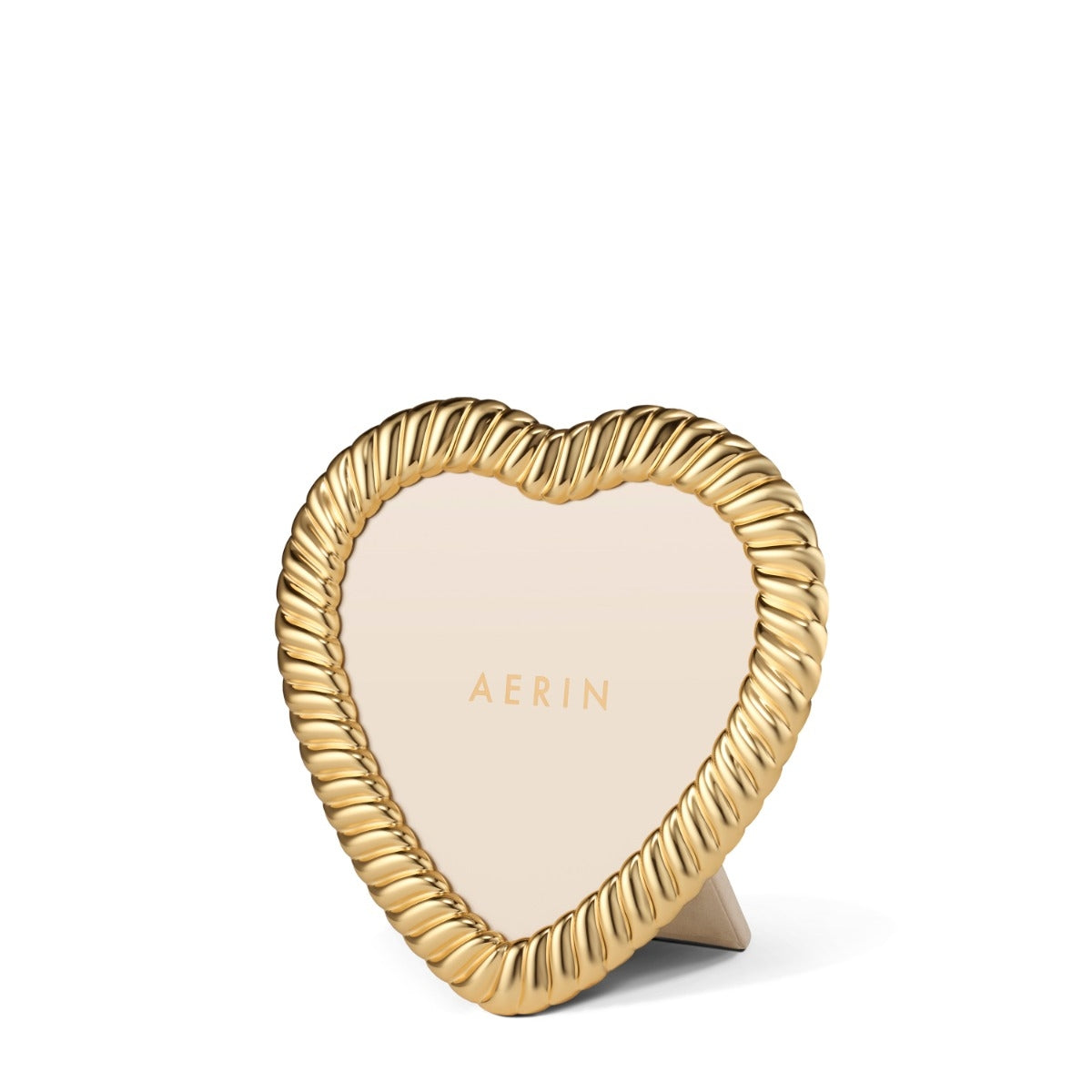 A heart-shaped picture frame with a twisted rope border and a light beige center, standing on a small matching base. The brand name 'AERIN' is printed in gold in the center.
