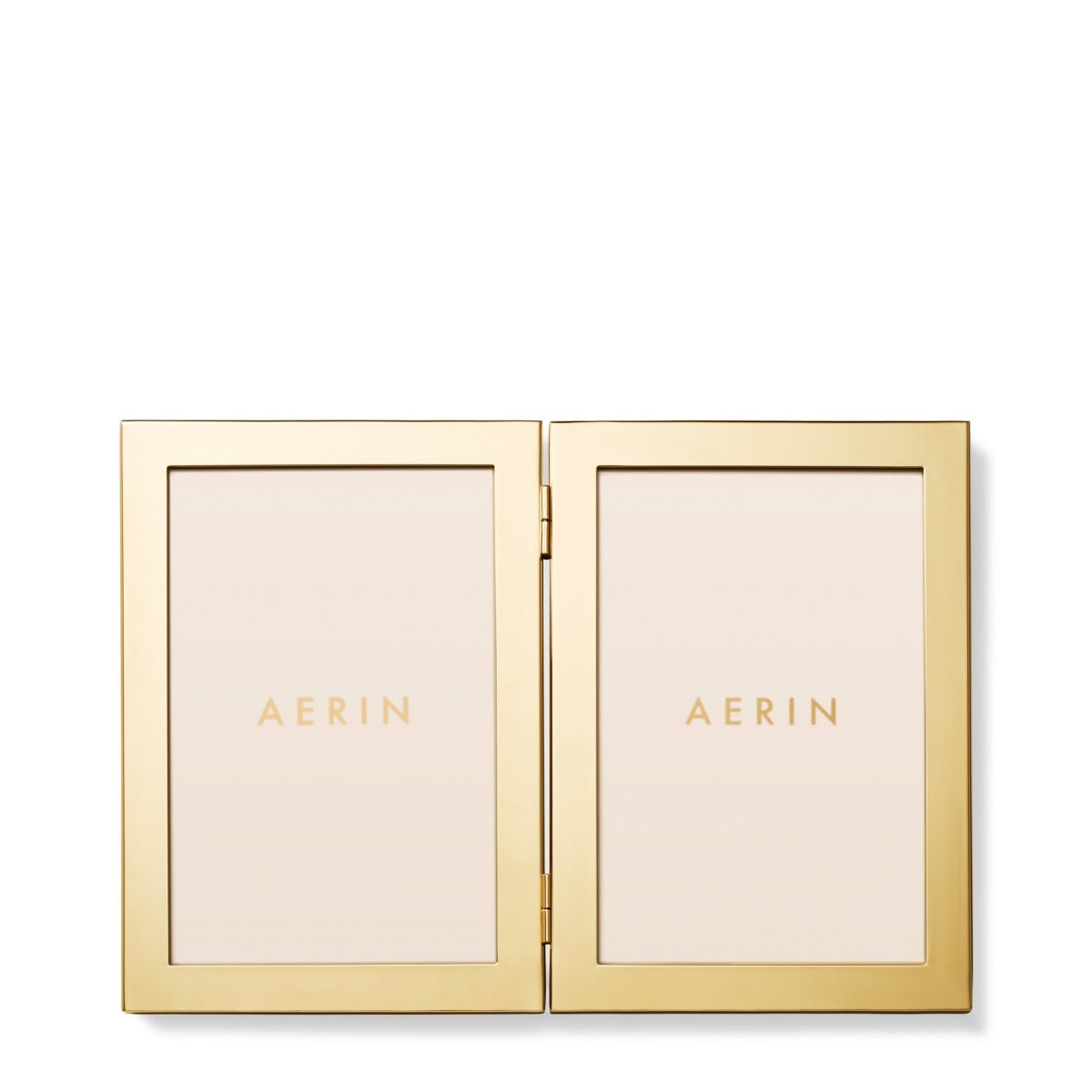 An open AERIN double-sided picture frame in polished gold-tone metal, displaying two cream-colored insert panels with the brand name 'AERIN' printed in gold on each side, set against a clean white background.
