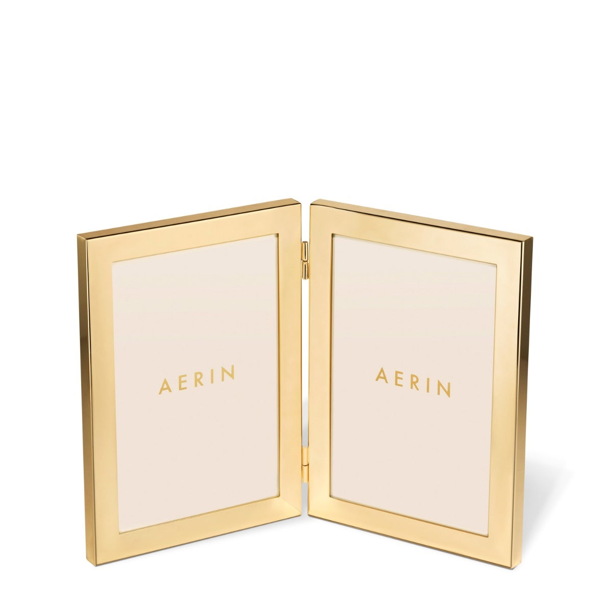 An open AERIN double-sided picture frame in polished gold-tone metal, displaying two cream-colored insert panels with the brand name 'AERIN' printed in gold on each side, set against a clean white background.