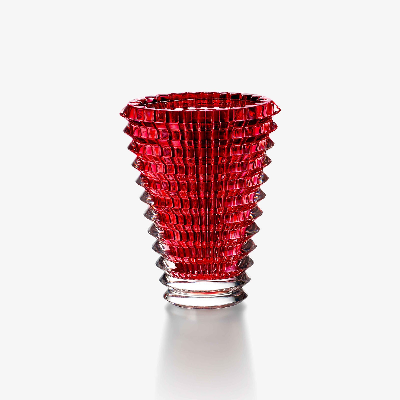 Red glass vase with textured design on a white background