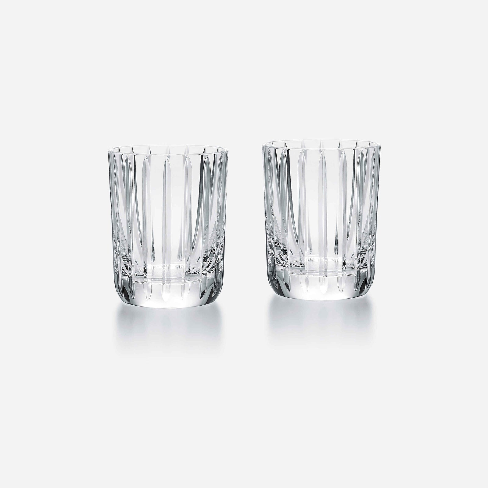 Two clear glass tumblers with a textured design on a white background