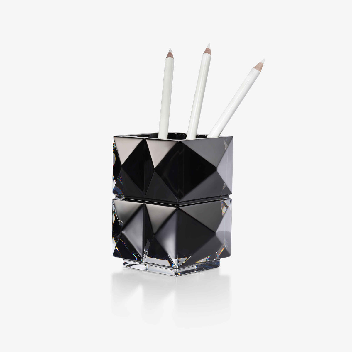 Black geometric pen holder with pens on a white background