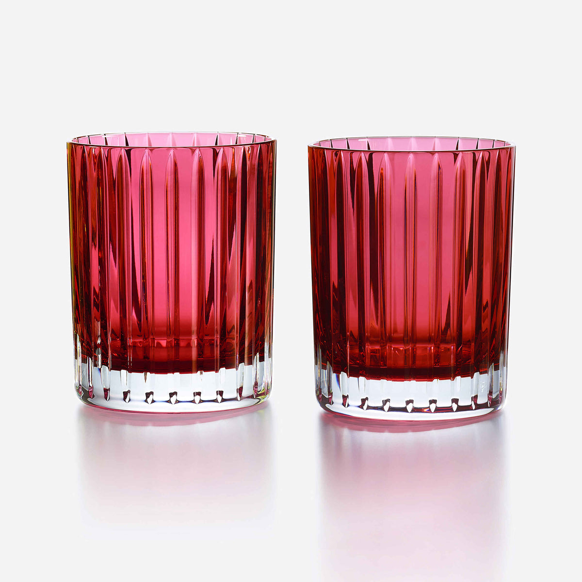 Two red glass tumblers with a textured design on a white background
