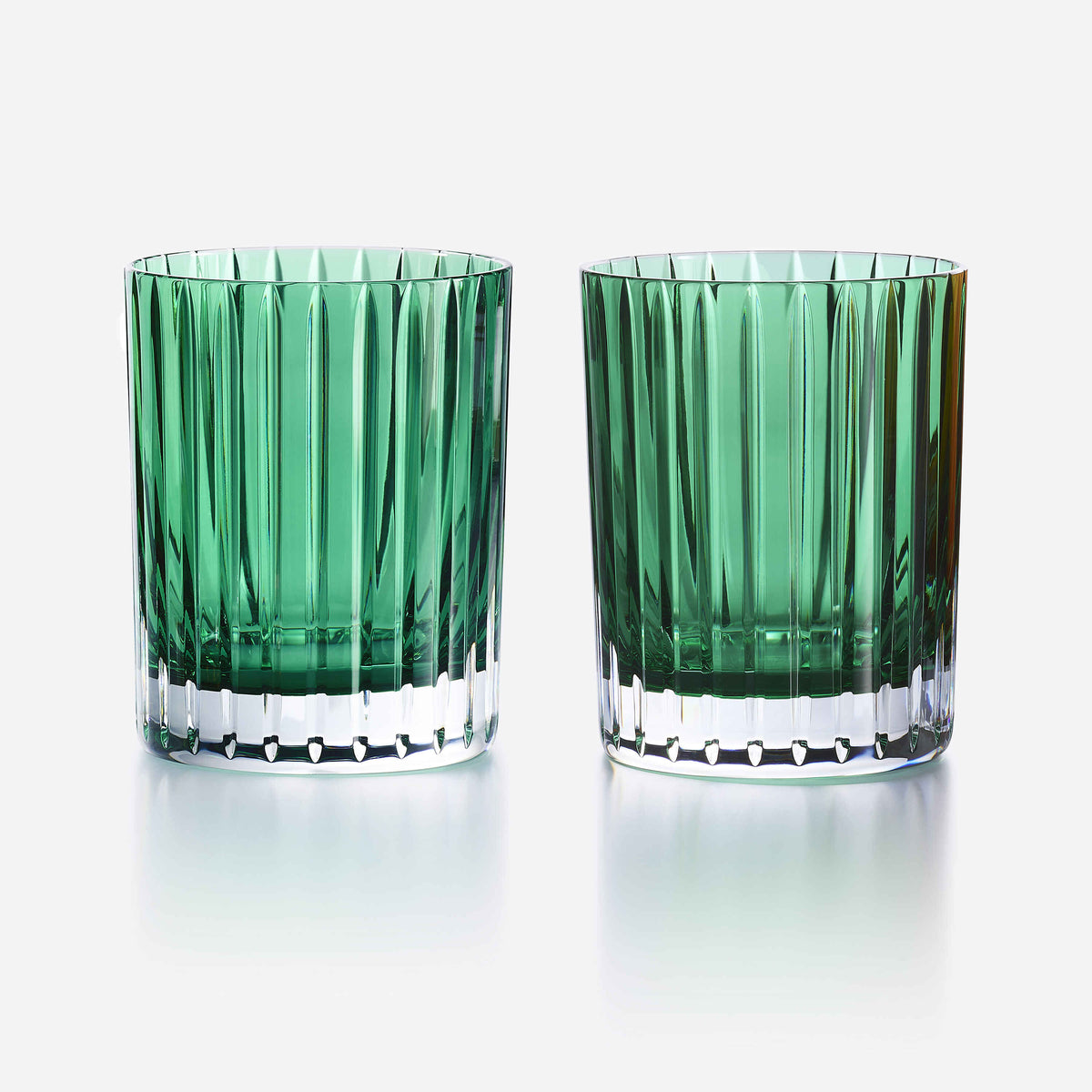Two green glass tumblers with a textured design on a white background