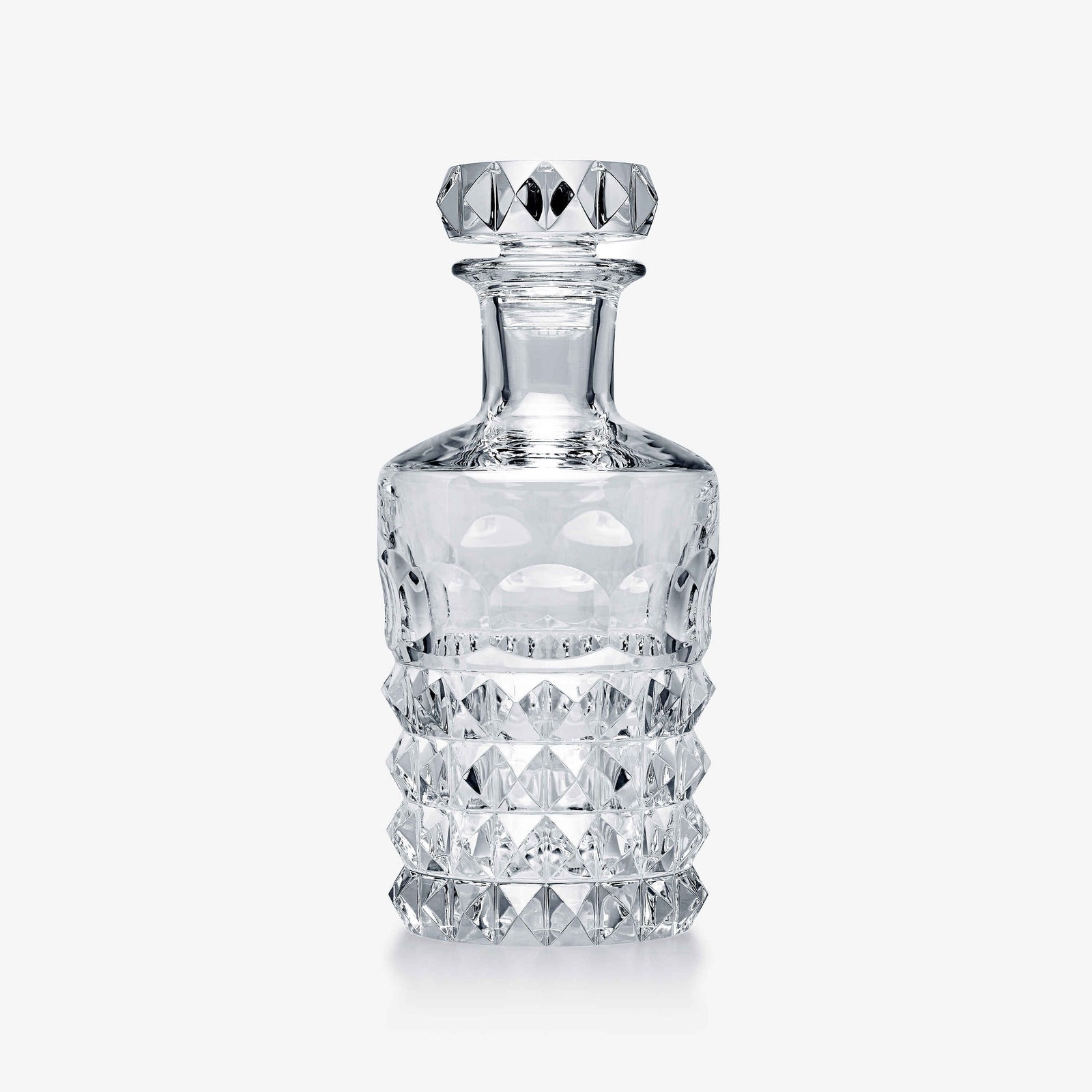 Clear glass decanter with diamond-cut design on a white background