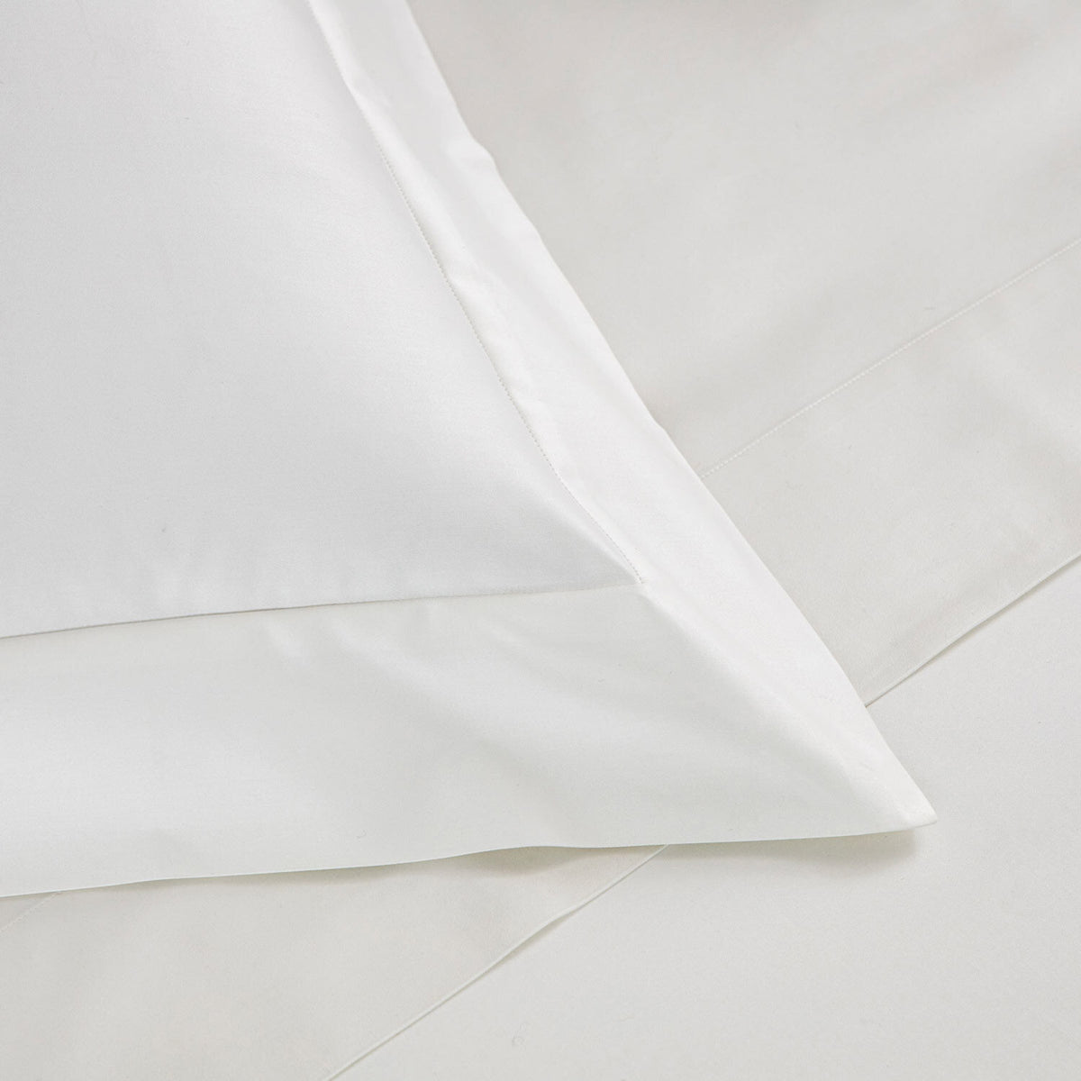 Close-up of a white pillowcase with a clean, folded-over border showing the fabric texture and stitching.