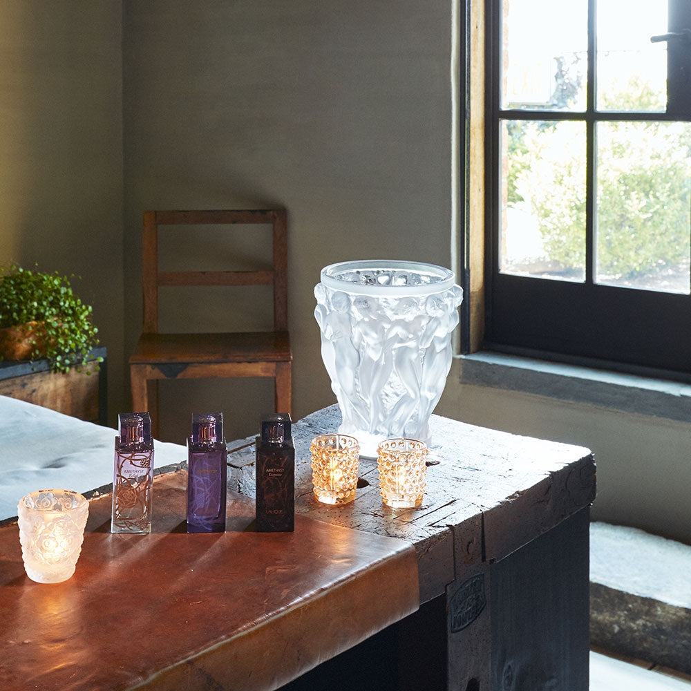 Decorative glass items on a wooden table near a window