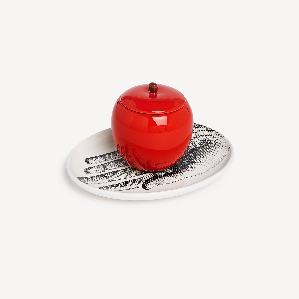Red ceramic jar with a textured lid on a decorative plate with a white background