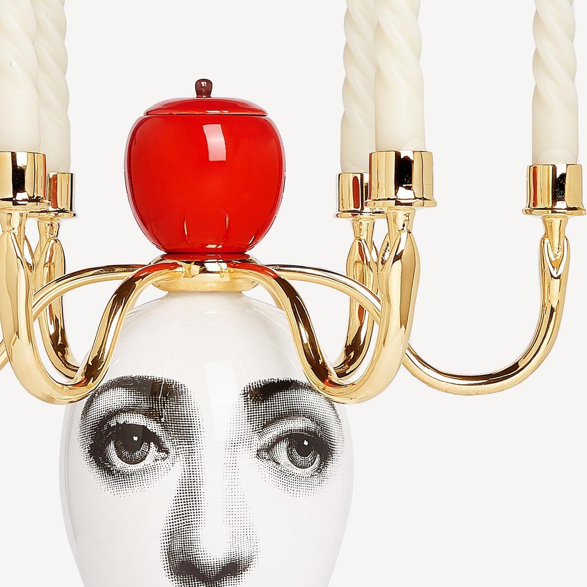 Decorative lamp with face design and red apple on a white background