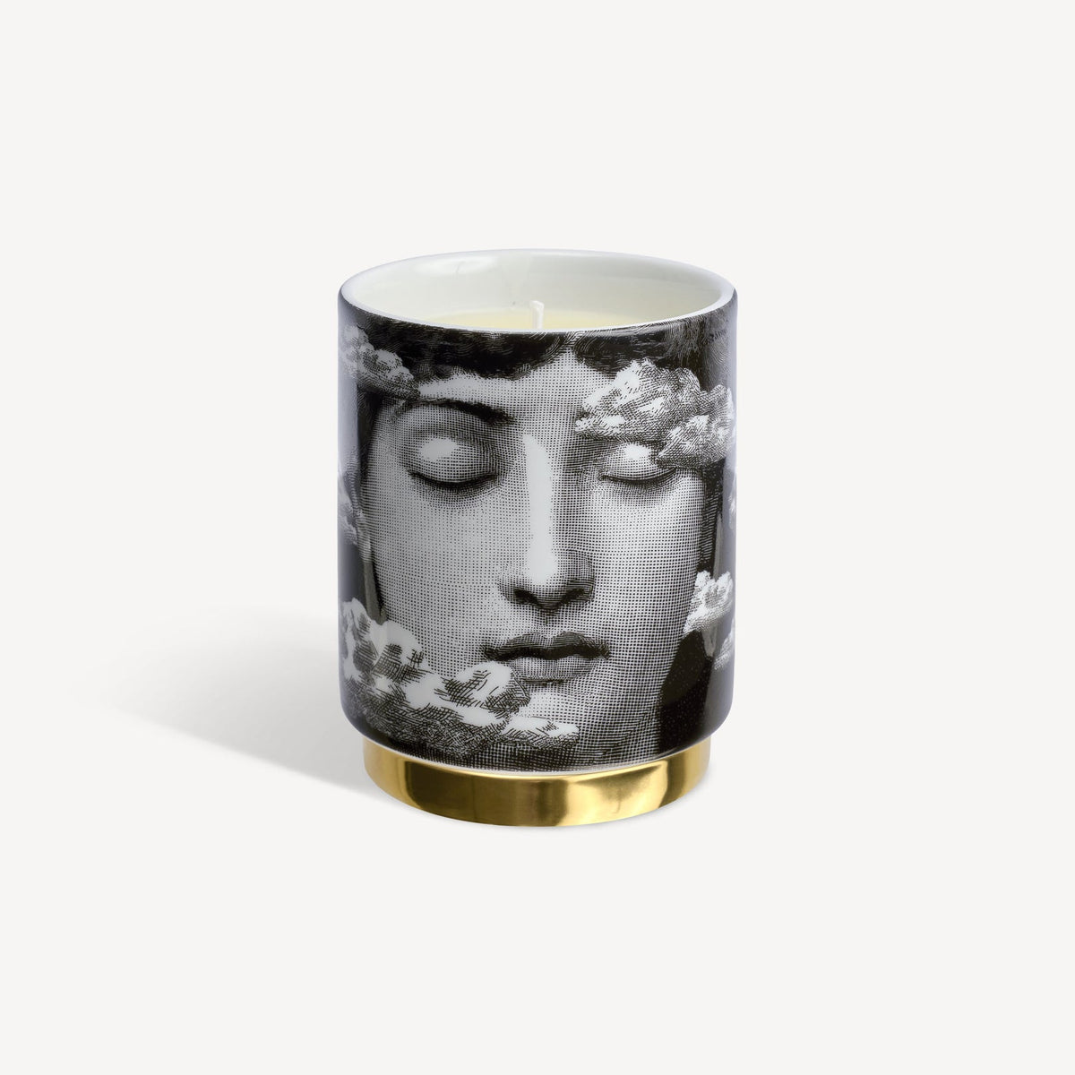 Candle with artistic design of a face and flowers on a white background