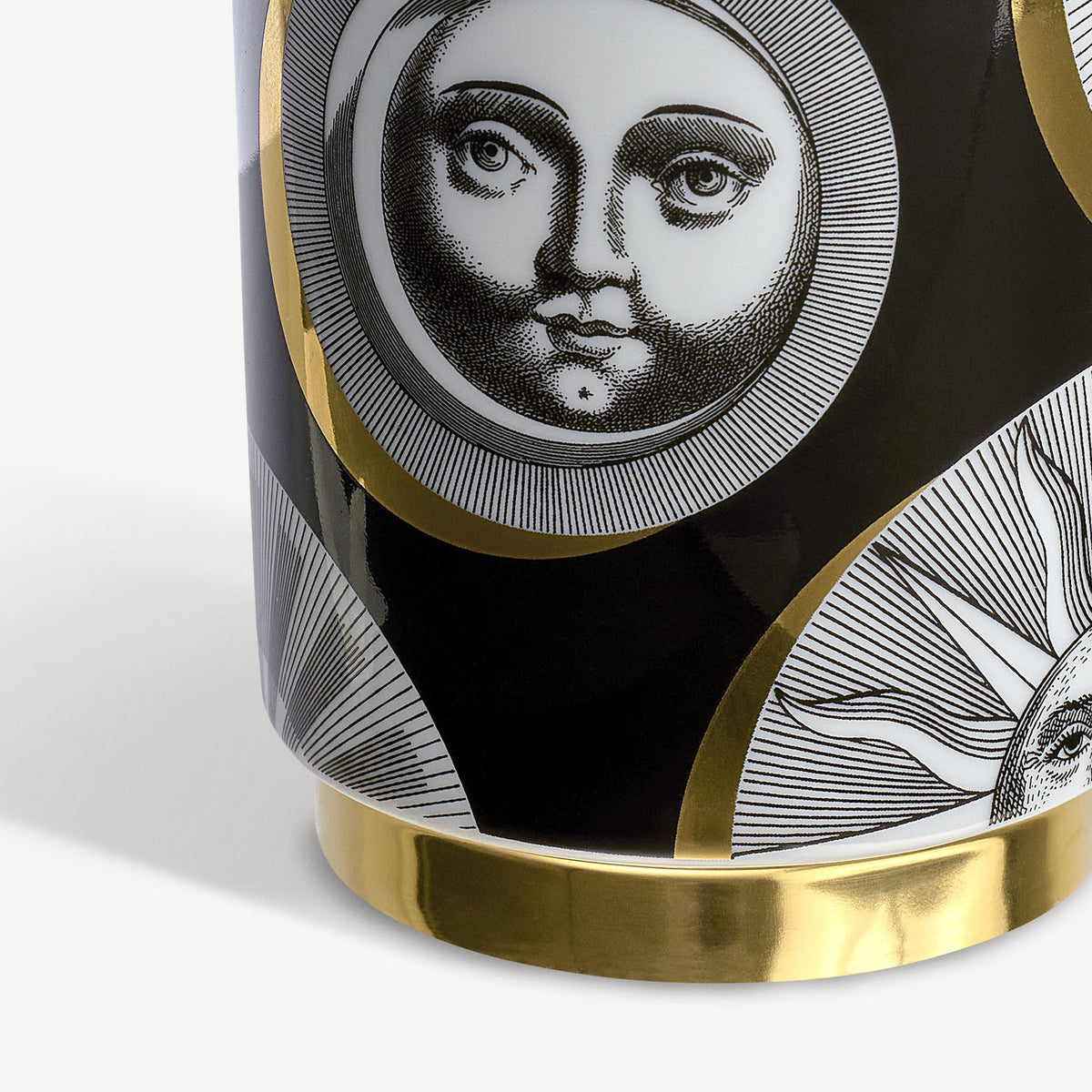Decorative item with face design and gold accents on a white background