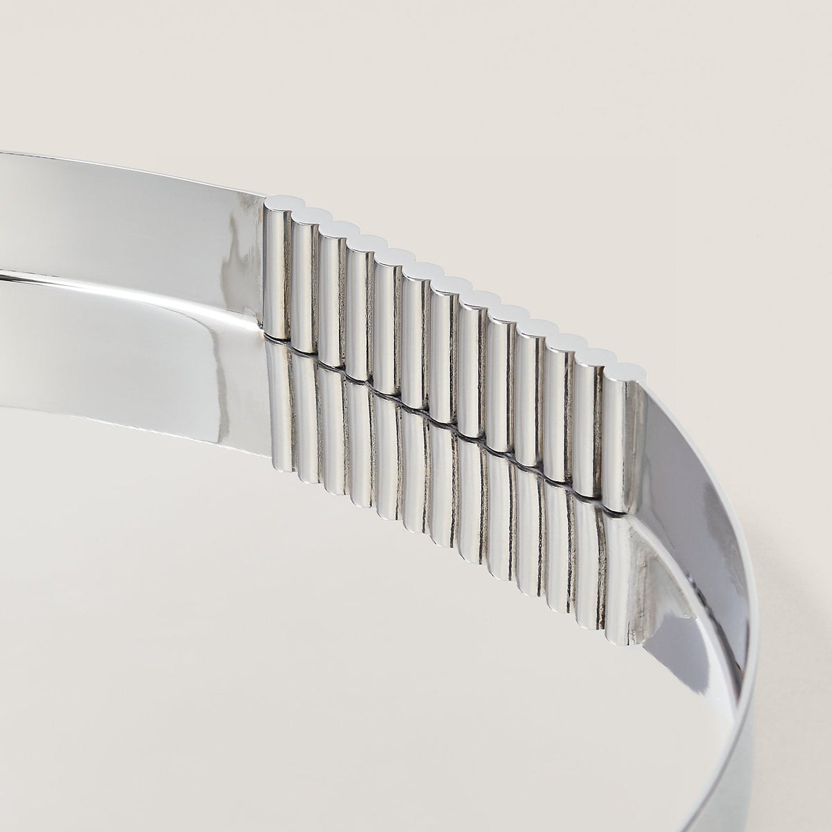 Close-up of a silver tray with a ribbed edge on a light background