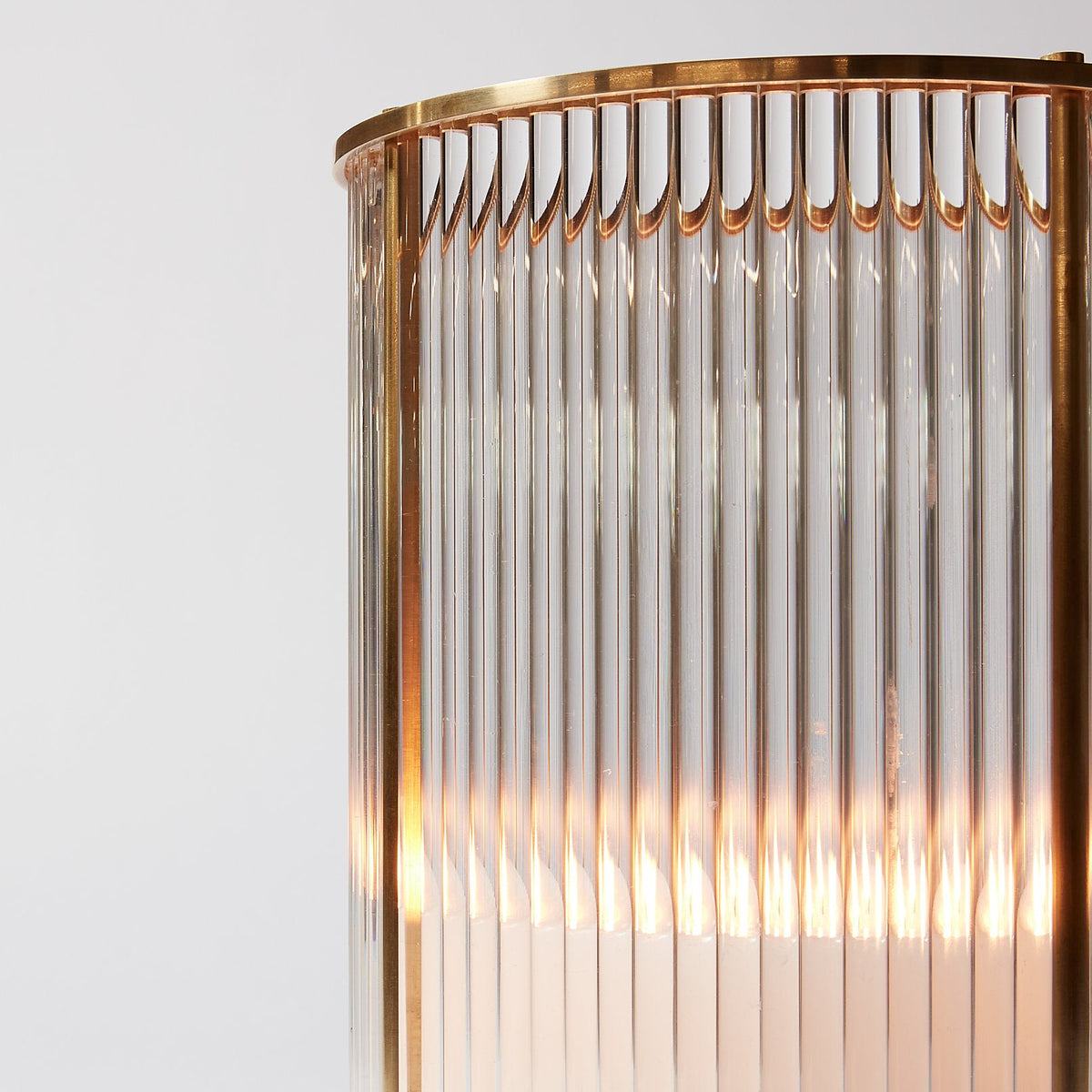 Decorative wall light fixture with gold frame and glass panels on a white background