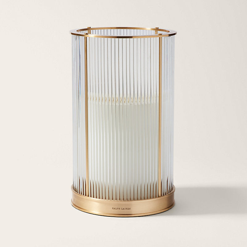 Decorative candle holder with brass base and glass cage on a white background