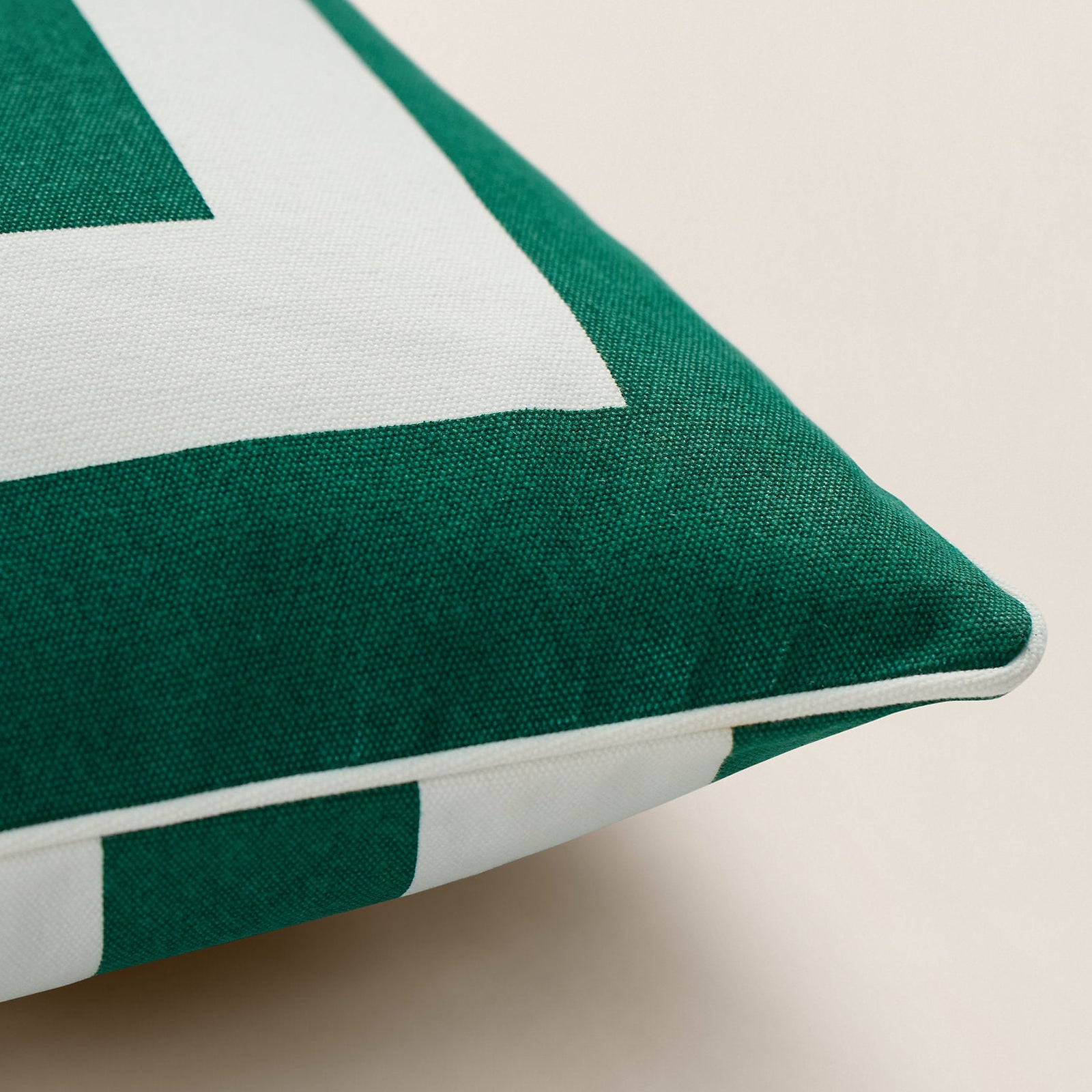 Green pillow with a logo on a beige background