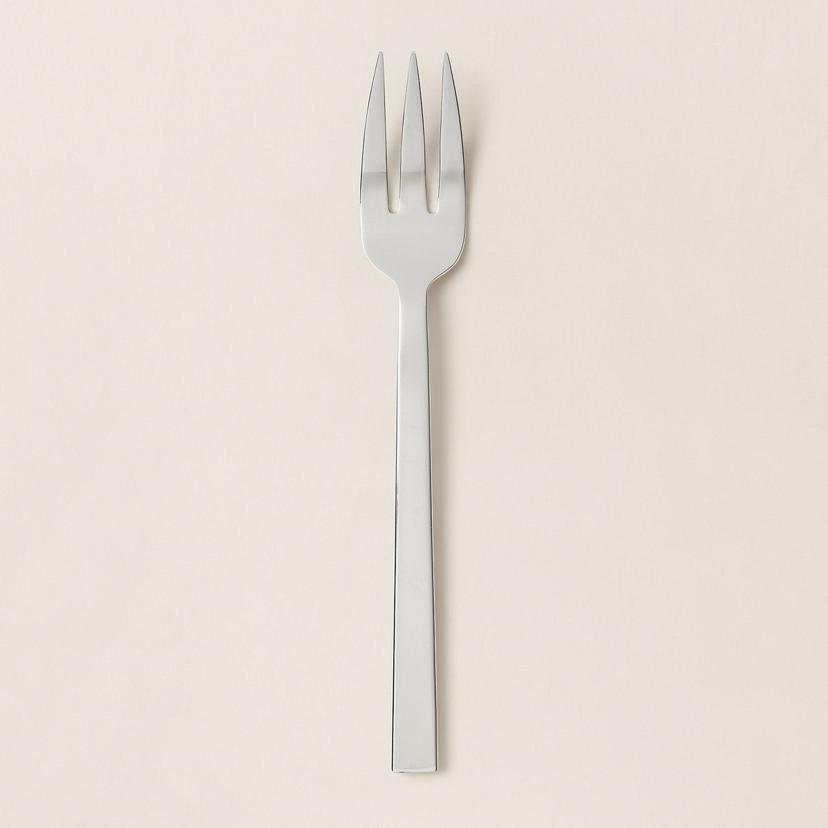 Stainless steel fork on a beige background