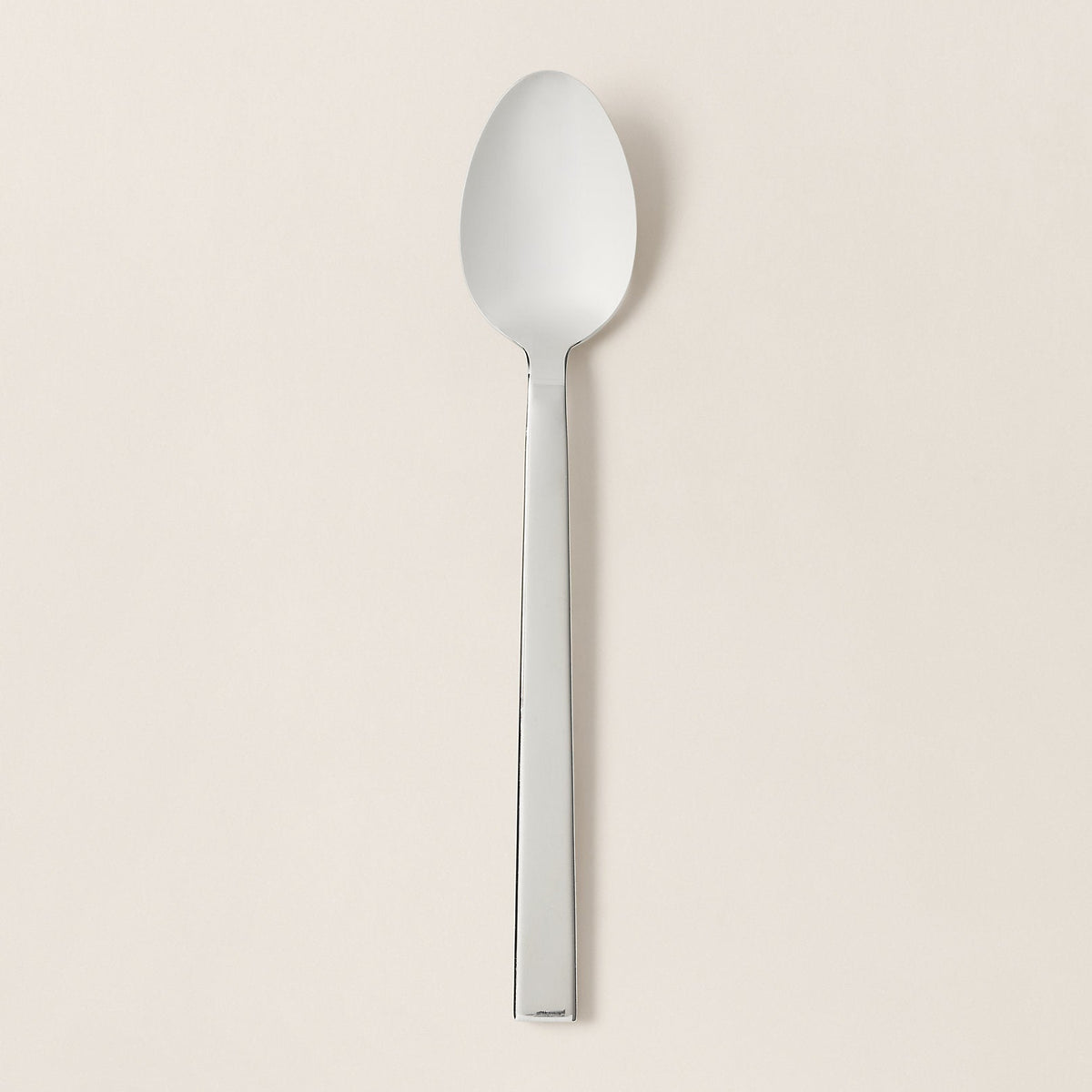 Silver spoon on a beige background