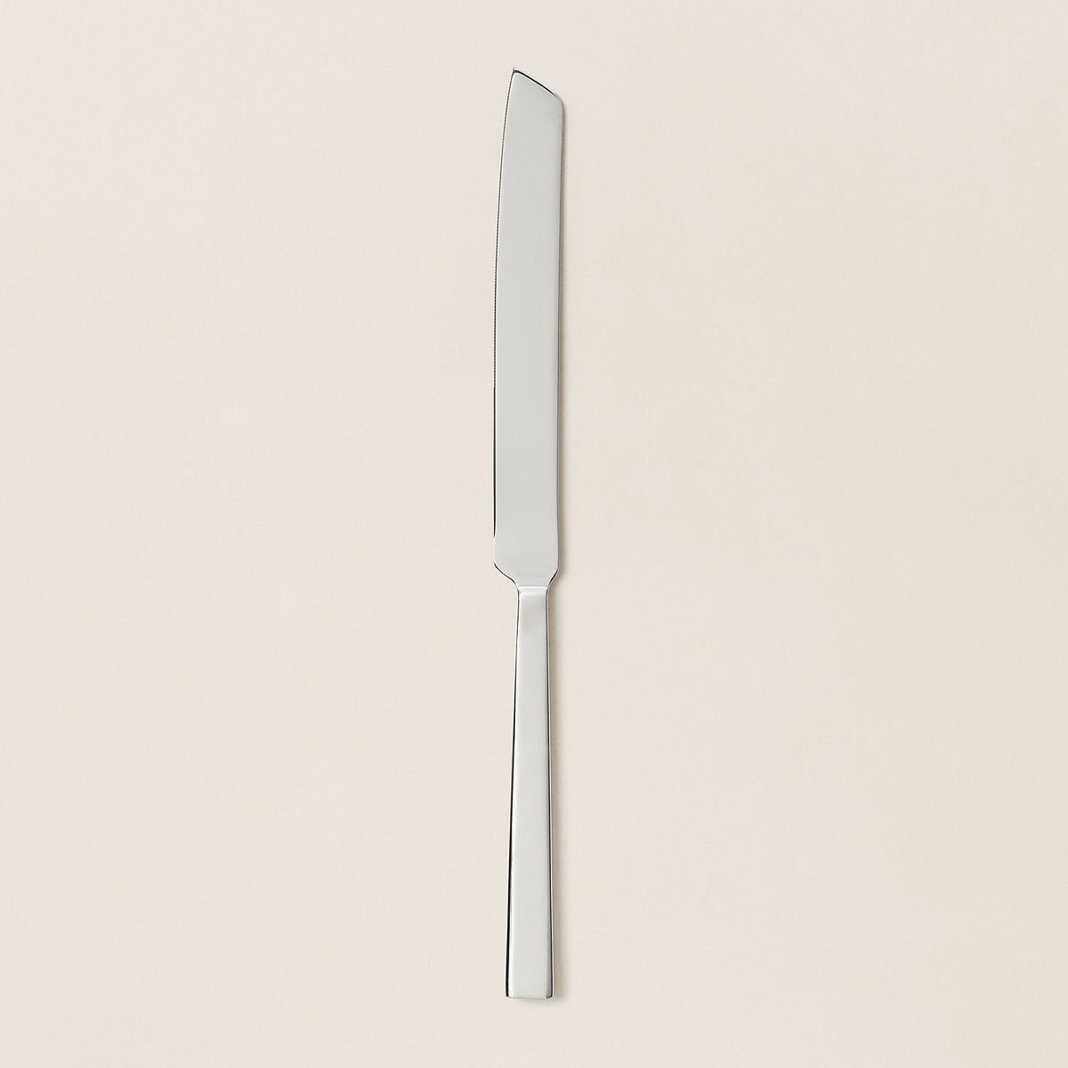 Silver knife on a beige background