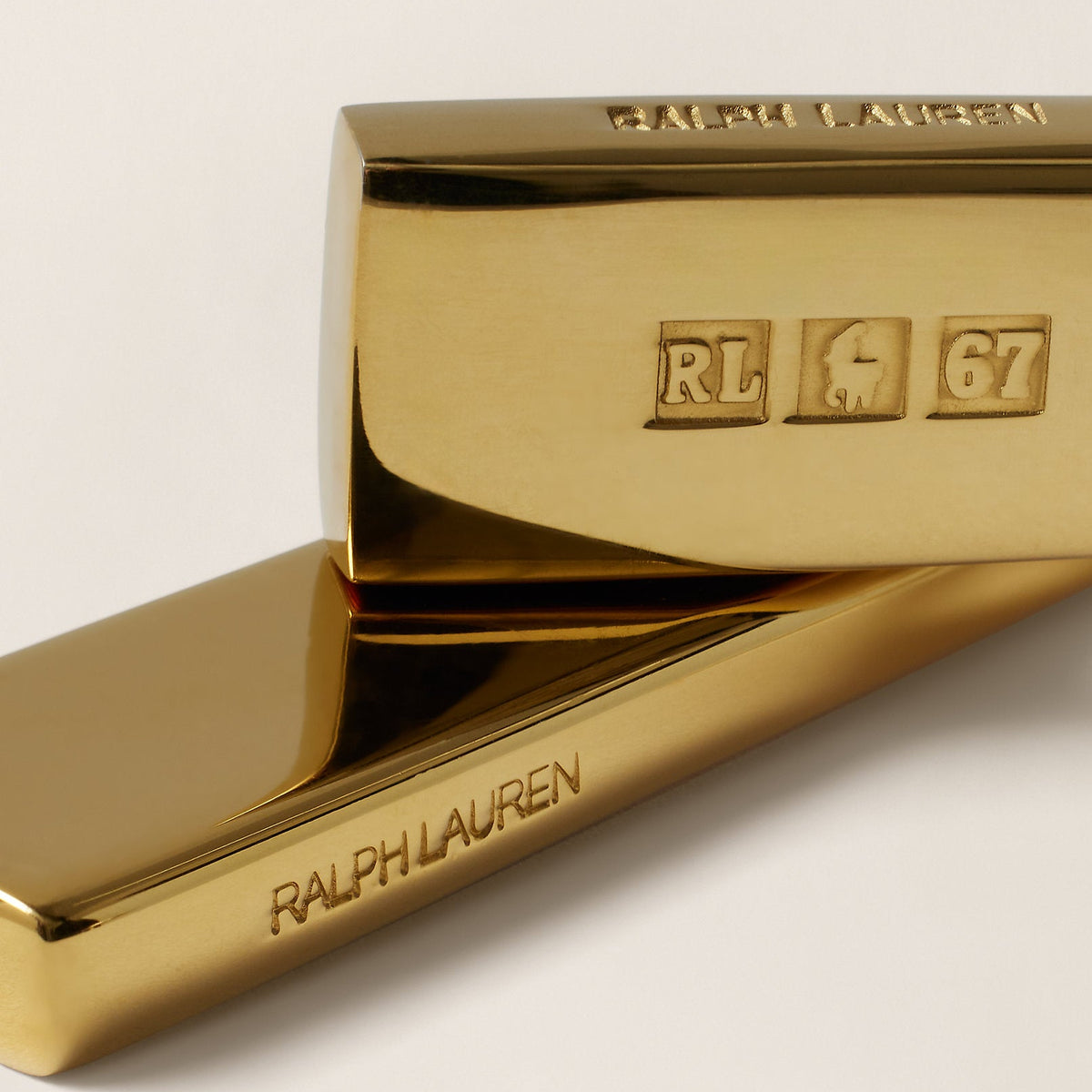 Gold tie clip with Ralph Lauren branding on a light background