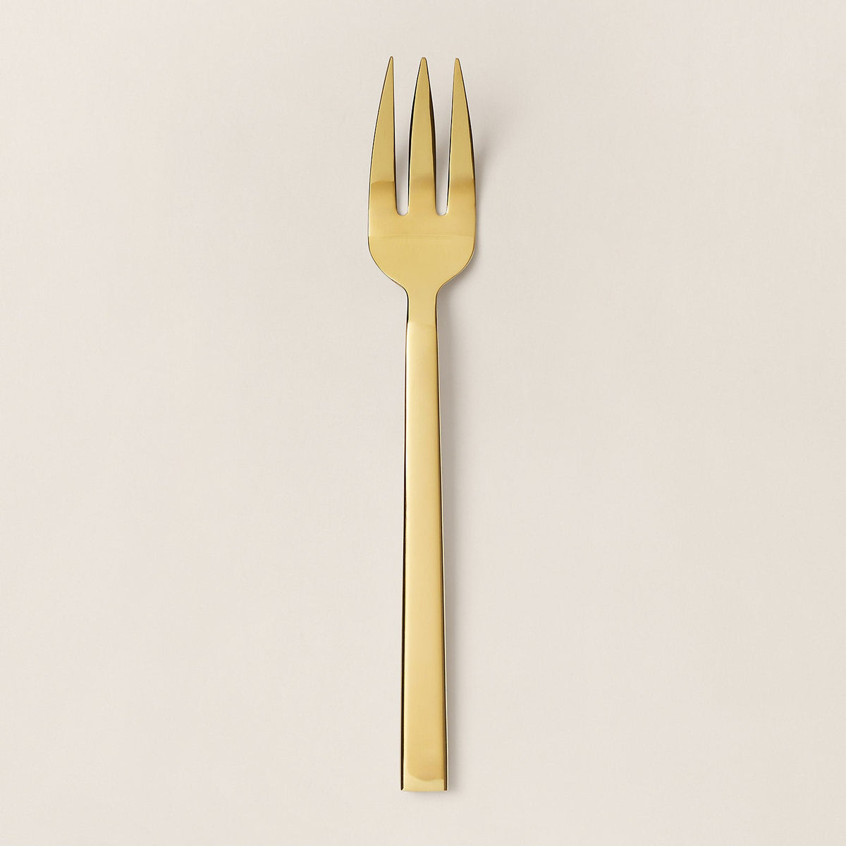 Gold fork on a beige background