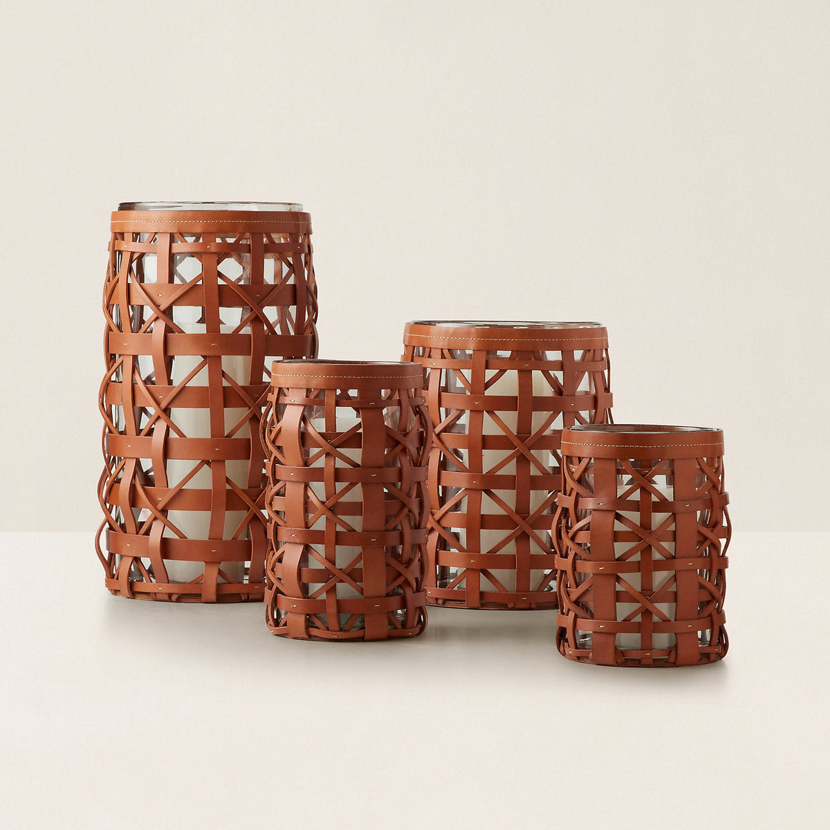 Set of four brown woven lanterns on a beige background