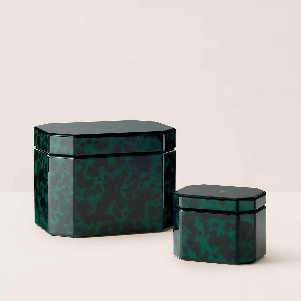 Two dark green marbled lacquer boxes with matching lids, one large and one small, displayed on a clean cream-colored surface.