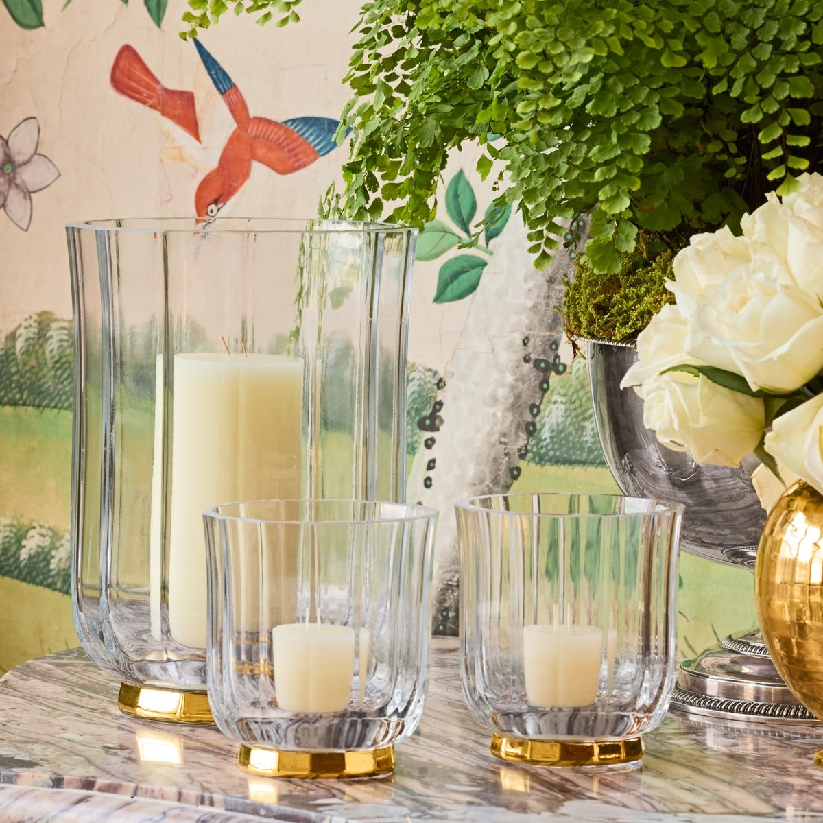 Clear glass vase with a gold base on a white background