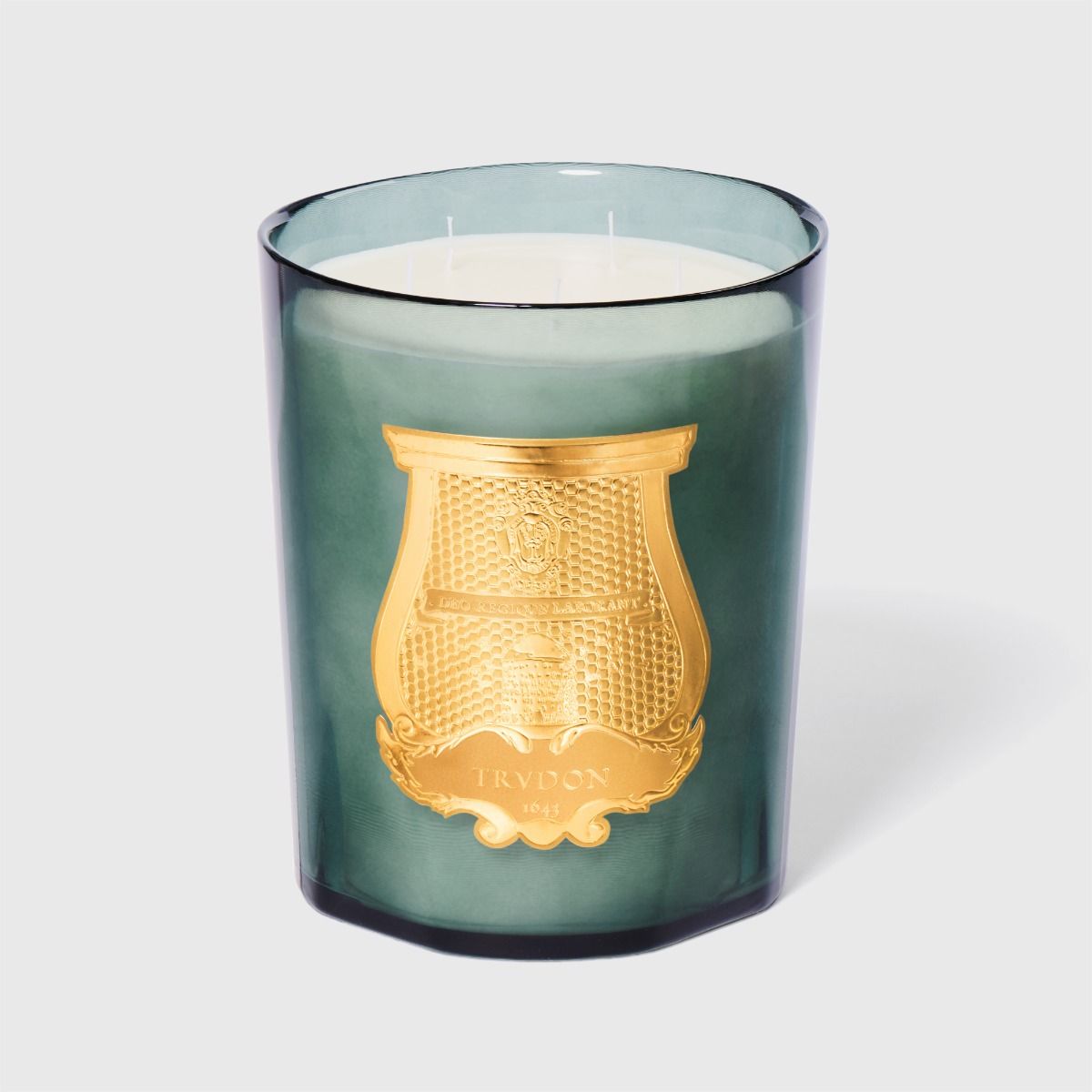 Green candle with gold emblem on a white background
